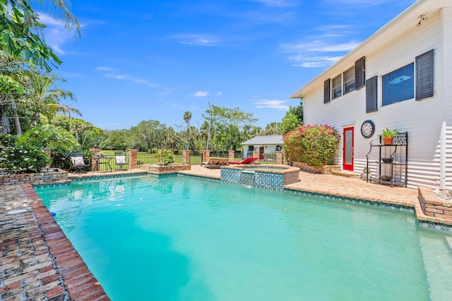 view of pool featuring a patio area, a pool with connected hot tub, and fence