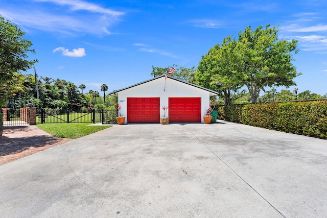 detached garage featuring fence and a gate