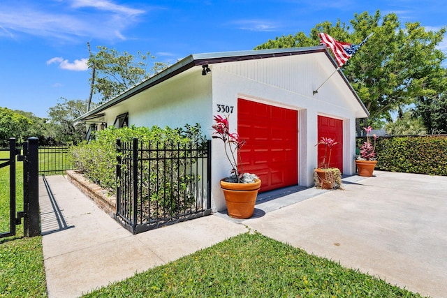 view of outbuilding with fence and a garage