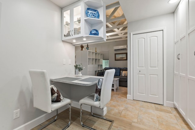 dining room featuring a wall mounted air conditioner and baseboards