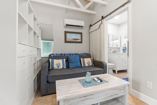 living room featuring baseboards, an AC wall unit, light tile patterned floors, and a barn door