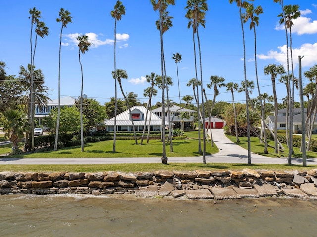 view of property's community featuring a lawn and a water view