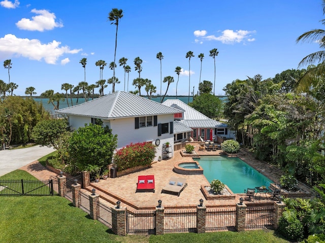 view of swimming pool with a fenced backyard, a gate, a yard, a pool with connected hot tub, and a patio