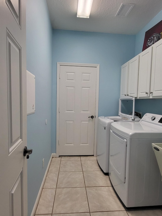 5105 E 1st Sq SW, Vero Beach, FL 32968 - washroom featuring separate washer and dryer, cabinet space, light tile patterned floors, and visible vents