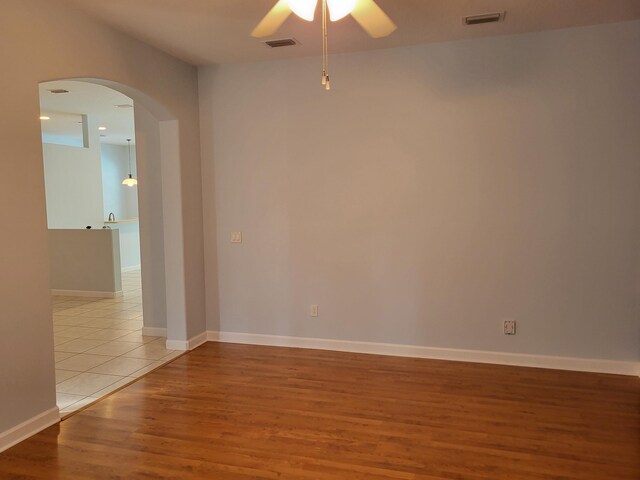 5105 E 1st Sq SW, Vero Beach, FL 32968 - spare room with arched walkways, a ceiling fan, visible vents, and wood finished floors