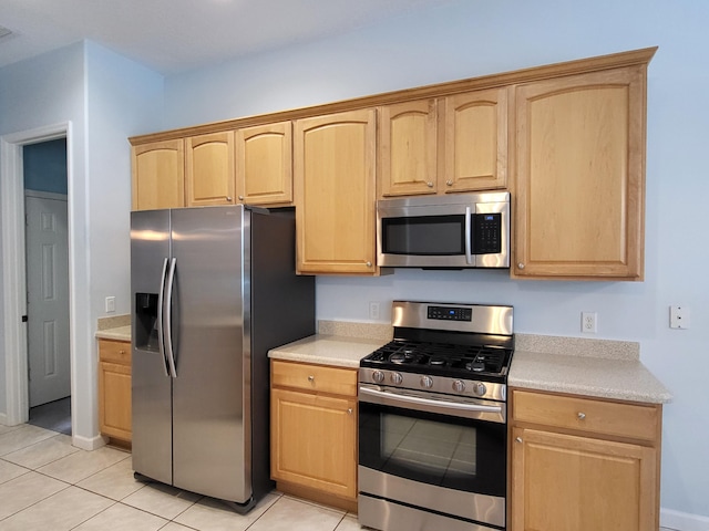 5105 E 1st Sq SW, Vero Beach, FL 32968 - kitchen with light countertops, appliances with stainless steel finishes, light tile patterned flooring, and light brown cabinets