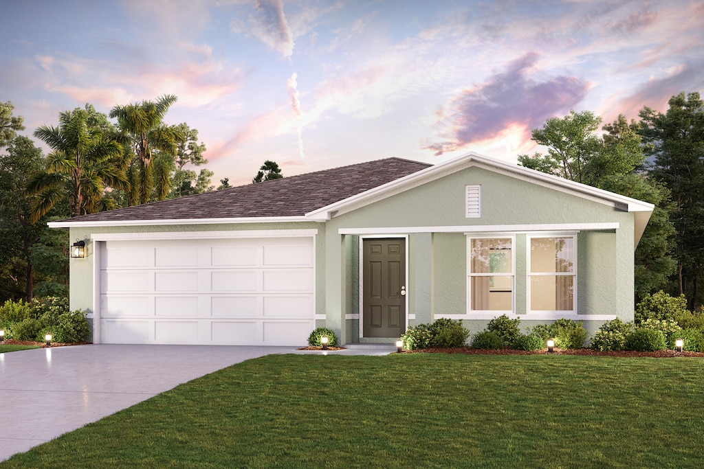 single story home with an attached garage, driveway, a front yard, and stucco siding