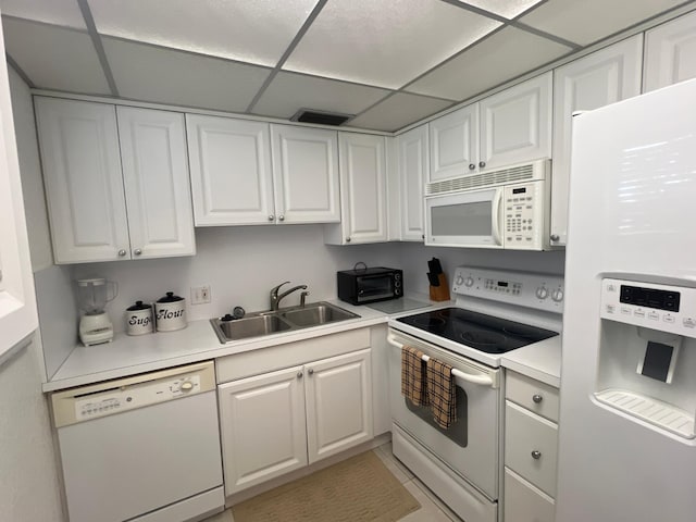 181 Ellesmere D Unit 181, Deerfield Beach, FL 33442 - kitchen with white appliances, white cabinets, light countertops, a drop ceiling, and light tile patterned floors