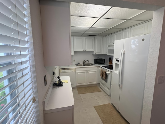 181 Ellesmere D Unit 181, Deerfield Beach, FL 33442 - kitchen featuring white appliances, white cabinetry, light countertops, light tile patterned floors, and a paneled ceiling