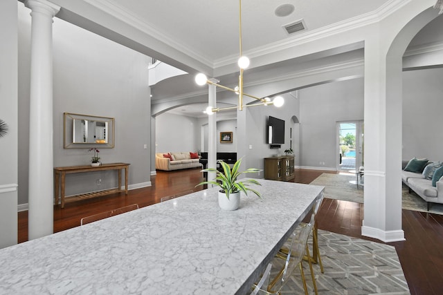 869 SW Habitat Ln, Palm City, FL 34990 - dining area featuring arched walkways, hardwood / wood-style floors, ornamental molding, ornate columns, and baseboards
