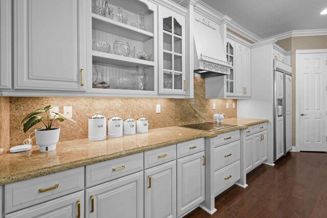 869 SW Habitat Ln, Palm City, FL 34990 - kitchen featuring paneled fridge, custom exhaust hood, glass insert cabinets, black electric stovetop, and white cabinetry