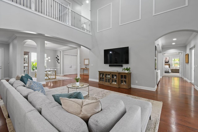 869 SW Habitat Ln, Palm City, FL 34990 - living room with arched walkways, crown molding, hardwood / wood-style flooring, a high ceiling, and baseboards