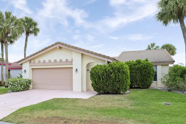 view of front of house with a garage, concrete driveway, a front yard, a tiled roof, and stucco siding