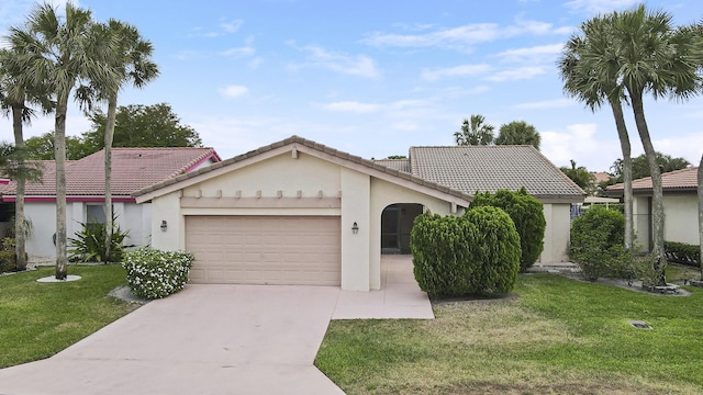 view of front facade featuring an attached garage, stucco siding, a front yard, and a tile roof