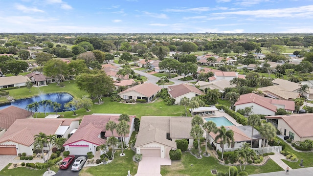 aerial view of residential area featuring a nearby body of water and a pool