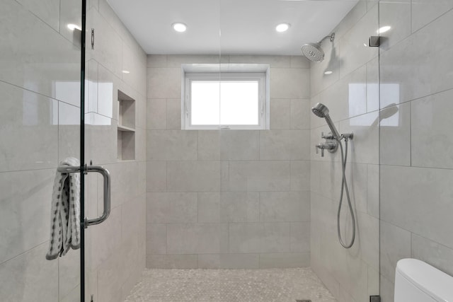 bathroom featuring toilet and a stall shower