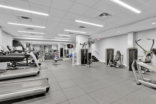 exercise room with a paneled ceiling and visible vents