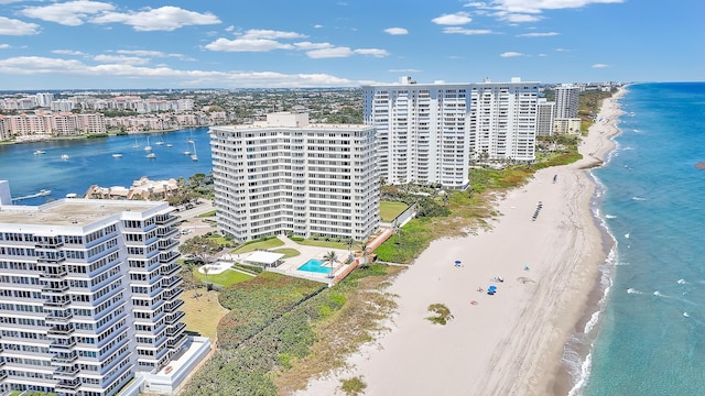 drone / aerial view featuring a city view, a view of the beach, and a water view