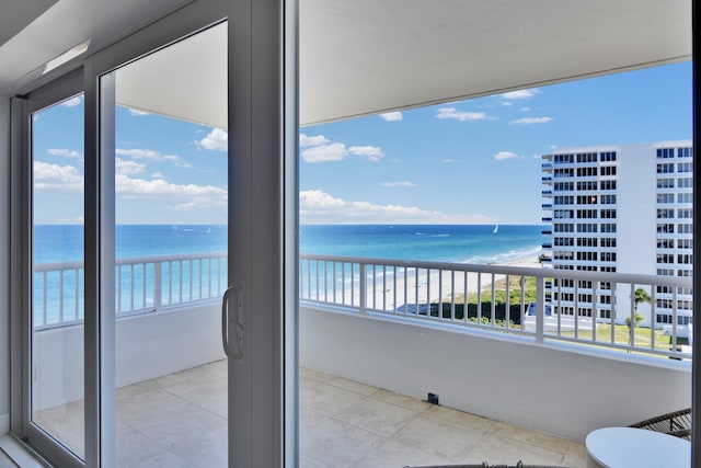 balcony featuring a beach view and a water view
