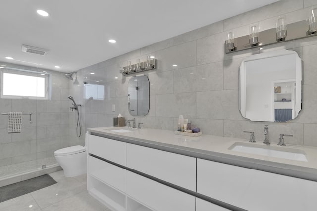 bathroom featuring toilet, a stall shower, a sink, and tile walls