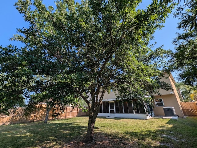 3325 Burdock Ave, Melbourne, FL 32904 - view of yard with central air condition unit, a sunroom, and a fenced backyard