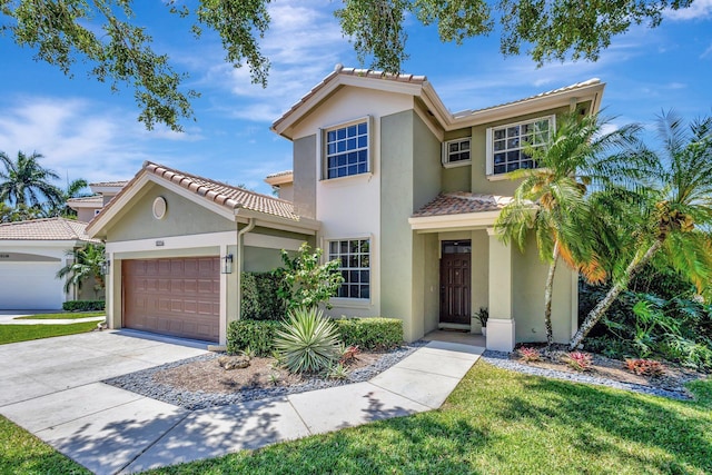 view of front of property featuring a tiled roof, an attached garage, concrete driveway, and stucco siding