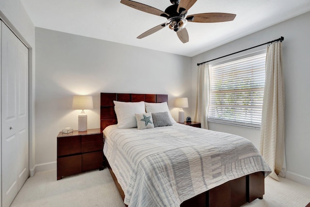 bedroom with light carpet, baseboards, and a closet