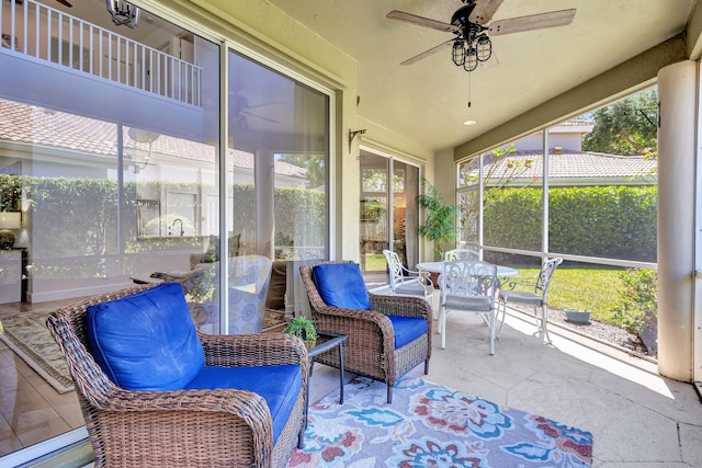 sunroom featuring outdoor dining area and ceiling fan