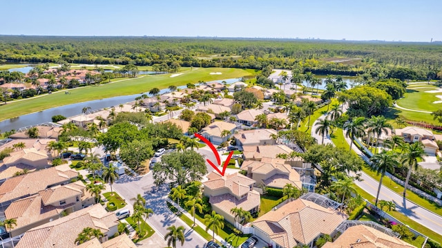 aerial view with a water view, a view of trees, a residential view, and golf course view