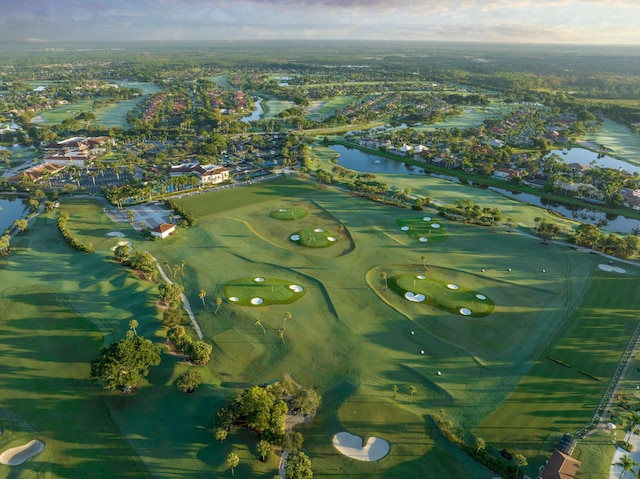 birds eye view of property with view of golf course and a water view