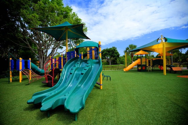 community play area with a lawn and fence