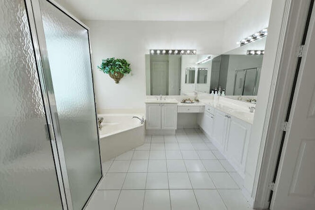 bathroom with tile patterned floors, a stall shower, a garden tub, and vanity
