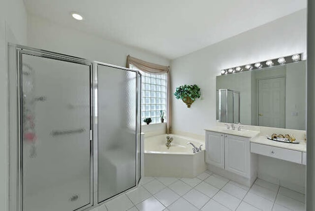 bathroom with a garden tub, a stall shower, tile patterned floors, and vanity