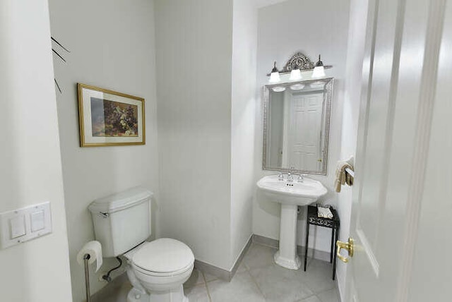 bathroom with toilet, tile patterned flooring, and baseboards