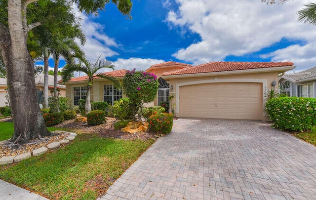view of front of property with stucco siding, decorative driveway, a tile roof, and a garage