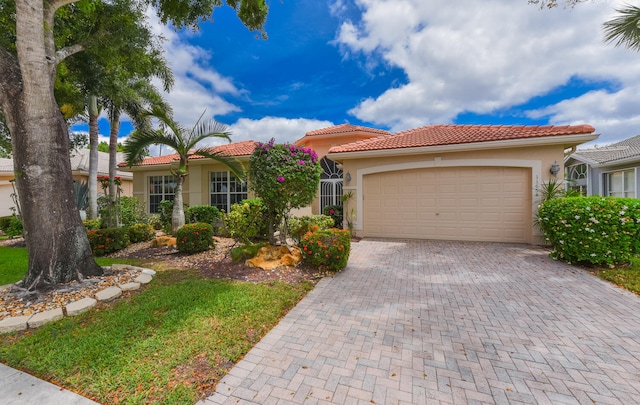 11654 Caracas Blvd, Boynton Beach, FL 33437 - view of front of house featuring decorative driveway, a garage, stucco siding, and a tiled roof