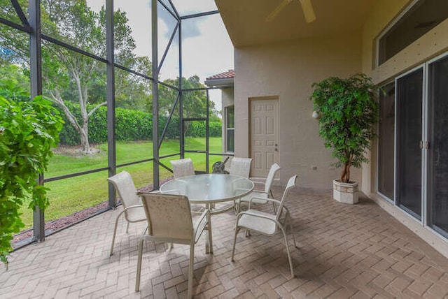 sunroom / solarium featuring a ceiling fan and outdoor dining space
