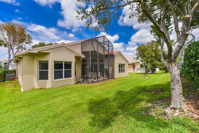 rear view of property with a yard and stucco siding
