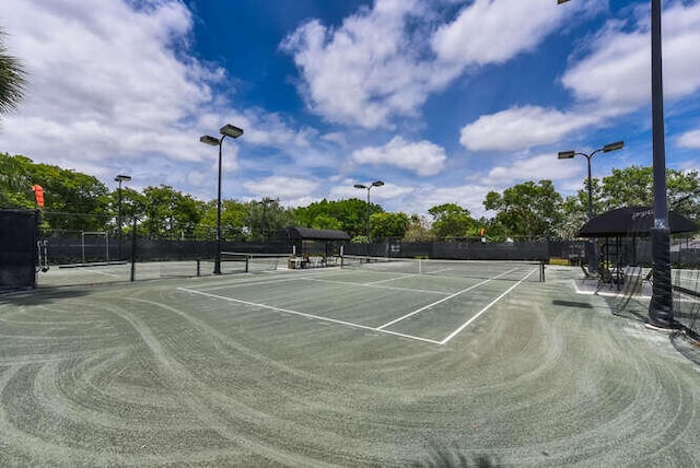 view of tennis court featuring fence