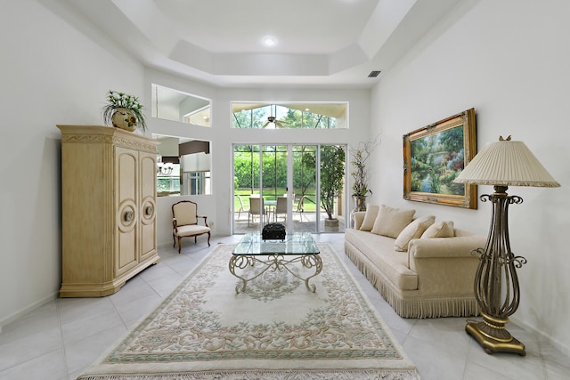 11654 Caracas Blvd, Boynton Beach, FL 33437 - living area featuring a towering ceiling, light tile patterned flooring, baseboards, a tray ceiling, and a ceiling fan