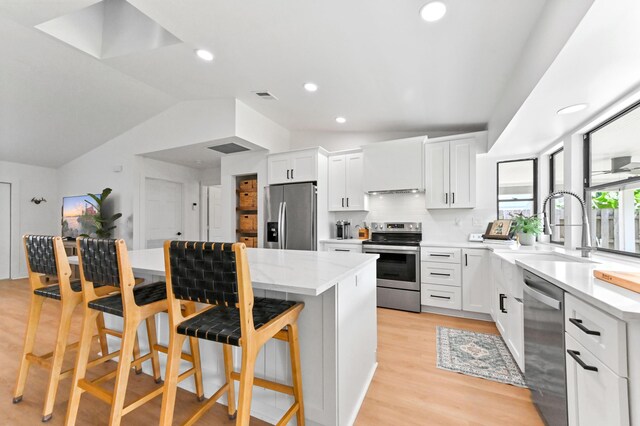 6214 Garrett St, Jupiter, FL 33458 - kitchen featuring a kitchen breakfast bar, a kitchen island, visible vents, a sink, and stainless steel appliances
