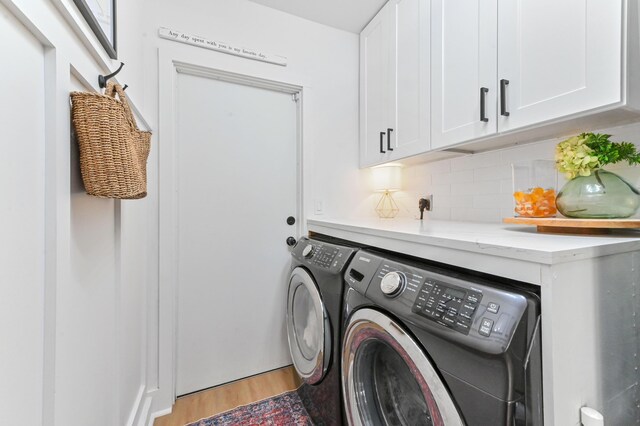 6214 Garrett St, Jupiter, FL 33458 - laundry room with cabinet space, light wood finished floors, and washer and dryer
