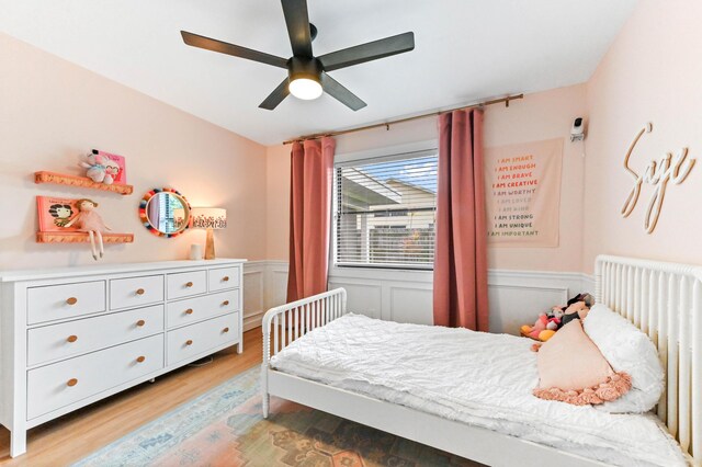 6214 Garrett St, Jupiter, FL 33458 - bedroom featuring ceiling fan, wainscoting, radiator heating unit, and light wood-style flooring