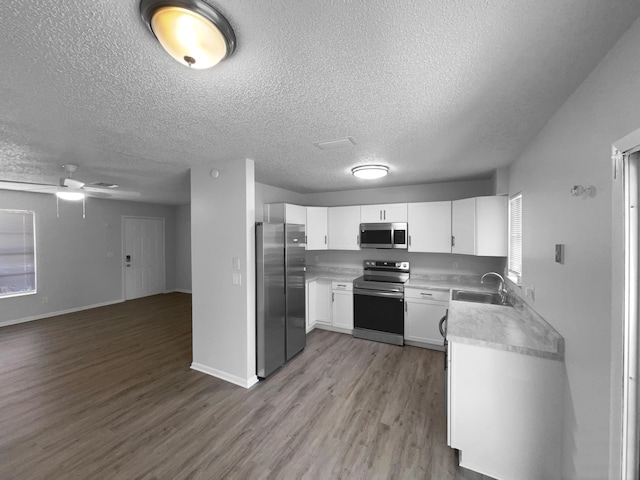 1541 SW Curry St, Port Saint Lucie, FL 34983 - kitchen featuring stainless steel appliances, open floor plan, wood finished floors, light countertops, and a textured ceiling