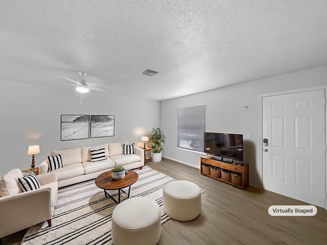 1541 SW Curry St, Port Saint Lucie, FL 34983 - living area featuring a textured ceiling, wood finished floors, and ceiling fan