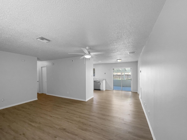 1541 SW Curry St, Port Saint Lucie, FL 34983 - unfurnished living room featuring a textured ceiling, wood finished floors, and a ceiling fan