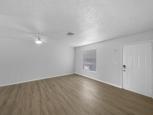 1541 SW Curry St, Port Saint Lucie, FL 34983 - unfurnished living room with wood finished floors, a textured ceiling, and a ceiling fan