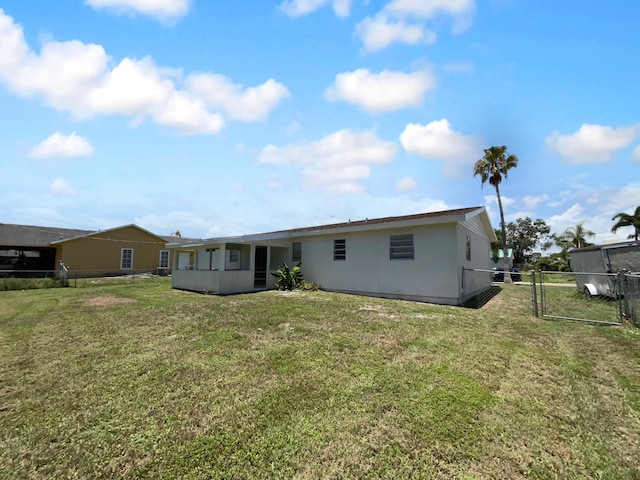 1541 SW Curry St, Port Saint Lucie, FL 34983 - back of property with a gate, stucco siding, and a sunroom