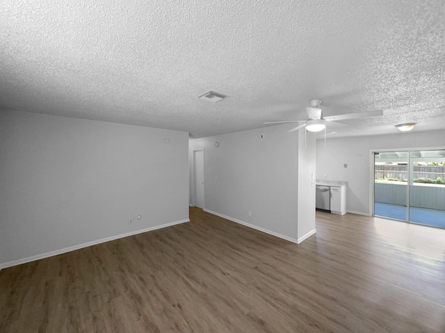 1541 SW Curry St, Port Saint Lucie, FL 34983 - unfurnished living room featuring wood finished floors, a textured ceiling, and a ceiling fan