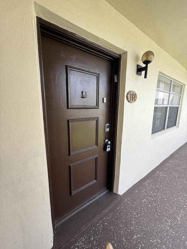 doorway to property featuring stucco siding